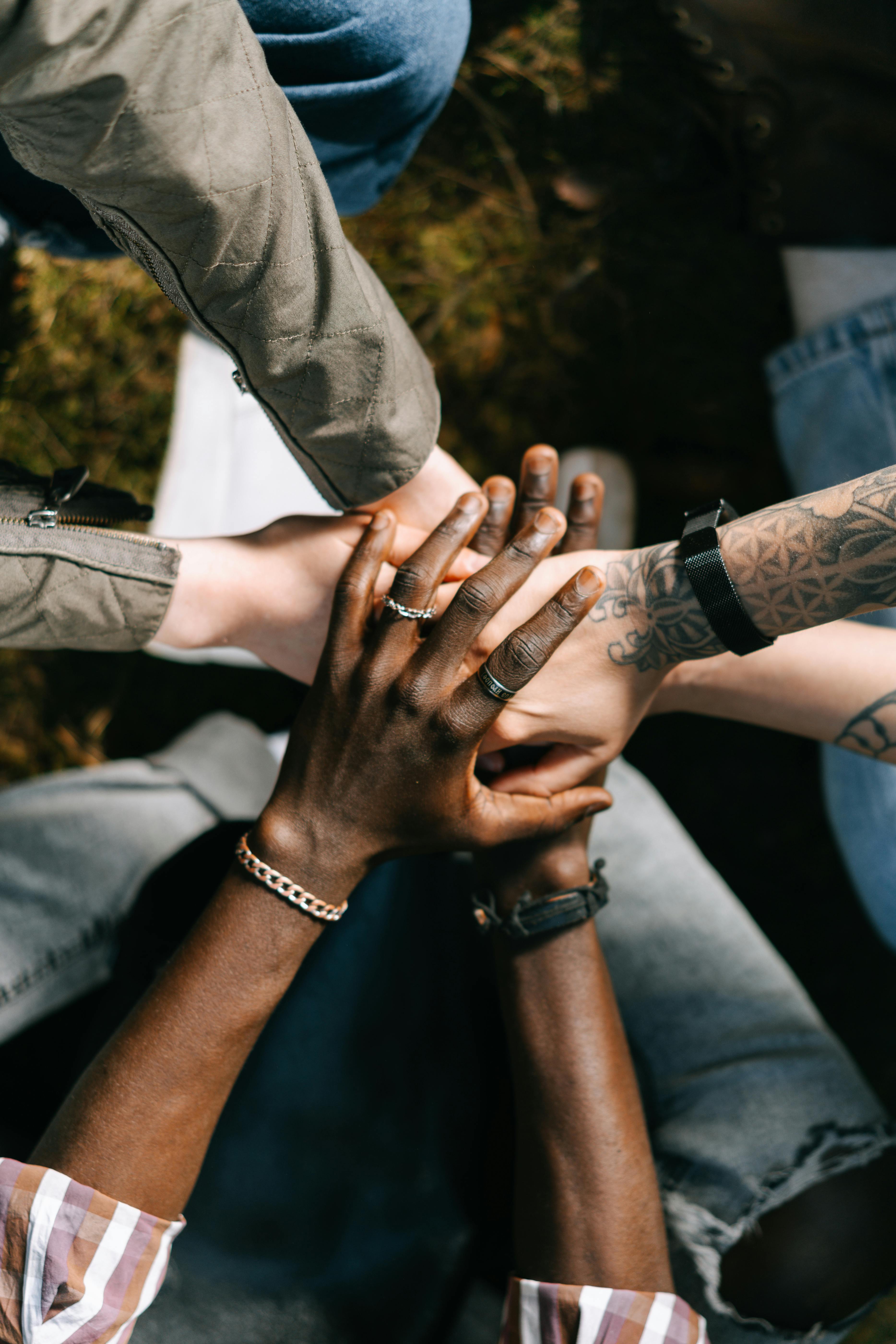 Community members placing their hands together symbolizing teamwork and collective impact